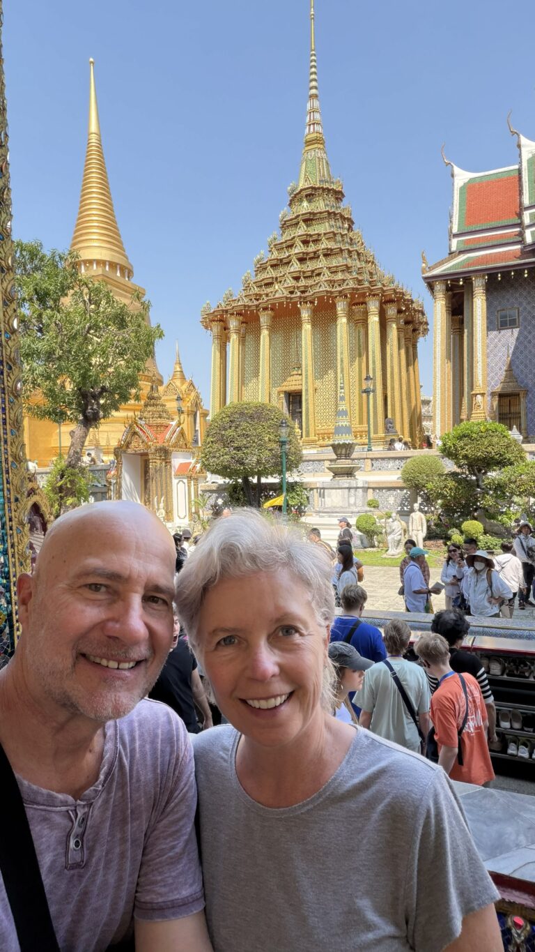 A couple in Bangkok Thailand at the Grand Palace in front of a Temple